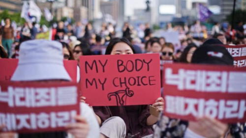 Fotografía de una manifestación en Corea del Sur. Mujeres cargan pancartas con diferentes consignas en su idioma natal pero también otras en inglés como “my body, my choice”.