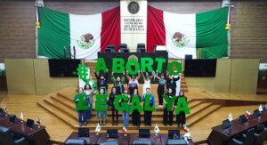 Banner que está ilustrado con la fotografía de un grupo de personas que sostienen unas letras gigantes que dicen "Aborto legal ya". Están en el pleno del Congreso de Durango.