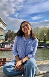 Fotografía de Jessica. Ella es una mujer joven que tiene el cabello oscuro arriba del hombro. Detrás de ella se ve un lago. 