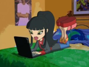 Fotograma de la serie “Bratz” donde está Jade acostada boca abajo en la cama usando una laptop. 
