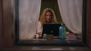 Fotograma de la serie “Sex and the City” en el que se ve desde una ventana a Carrie Bradshaw usando una laptop.